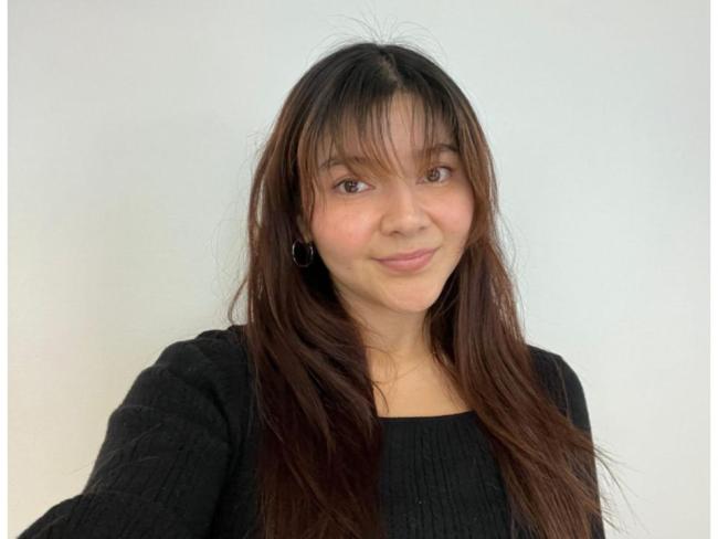 Mayra wearing a black blouse, smiling